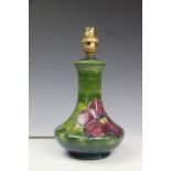 A Moorcroft Clematis pattern lamp base, decorated with floral sprays against a green ground,