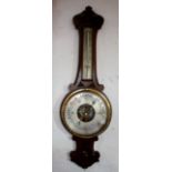 An Edwardian carved oak aneroid barometer, with thermometer,