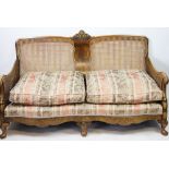 A 1920's walnut three piece bergere suite, comprising two seater settee and two arm chairs,