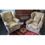 An early 20th century wing back library chair, with patterned upholstery, on cabriole legs,