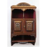 A late Victorian Aesthetic carved walnut hanging cabinet, with open shelf above two doors,