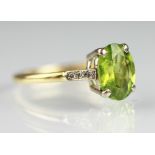 A peridot and diamond ring, the central,