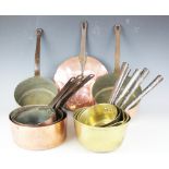 An assortment of 19th century and latter copper and brass country house sauce pans,
