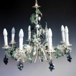 A toleware eight branch chandelier, decorated with vine leaves and grapes,