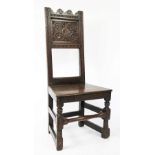 An 18th century provincial oak chair, with panelled back and solid seat, on turned and block legs,