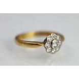 A diamond daisy cluster ring, the central diamond within a surround of eight further diamonds,