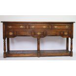 A George III style oak dresser base, with six drawers and pot shelf, on turned legs,