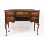 A 1920's walnut inverted breakfront desk, with an arrangement of five drawers,