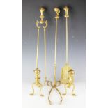 A three-piece brass fire iron set and matching andirons, each with ball and claw finial designs,