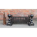 A pair of cast iron and brass fire dogs and grate,