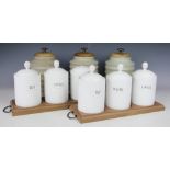 A set of three celadon glazed storage jars, with ribbed bodies and oak covers,