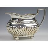 A silver milk jug, Barker Brothers, Chester 1912, the wrythen lower section below a gadrooned rim,