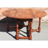 An 18th century style oak gate leg table, with oval top, on turned and block legs,