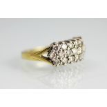 A three row diamond ring, the three rows of brilliant cut diamonds, each claw set in white metal,