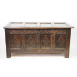 An early 18th century oak coffer, with four panel top and later carved detailing to the front,