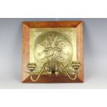 A late 19th century brass wall sconce, the convex back decorated with two dolphins, and two arms,