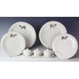 An assortment of contemporary grey glazed plates, each decorated with a cow design,