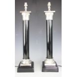 A pair of table lamps, each in the form of a column with chromed mounts,