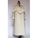 A Victorian ladies coat/cape, circa 1900, in cream with applied ribbon detail and rabbit fur trim,