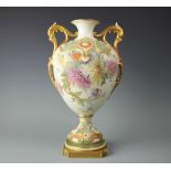 A Royal Worcester twin handled vase, with applied scroll detailing and painted with floral sprays,