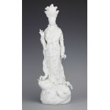 A Chinese style porcelain blanc de chine figure of Guanyin, modelled upon a carp,