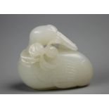 A Chinese white Jade carving of a seated goose/Mandarin duck with peach blooms,