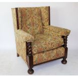 A pair of 1920's oak wing back library chairs, with floral upholstery and barley twist uprights,