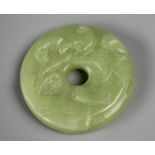 A Chinese carved jade Bi disc, carved with a beast and ruyi,