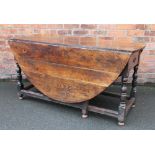 An 18th century oak gate leg table, with side drawer, on turned and block legs,