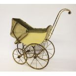 A Victorian dolls pram, with padded interior upon four spindle wheels, with turned ceramic handle,