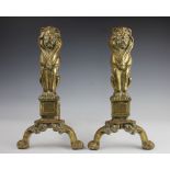 A pair of brass fire dogs, modelled as lions, 44cm,