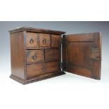 An 18th century style oak spice cabinet, with panelled door enclosing six drawers, 31cm H x 35.