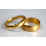 A 22ct yellow gold wedding band, size N, along with another size M, gross weight 7.