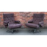 A pair of 1970's Retro swivel office chairs, with button back upholstery, on tubular metal frames.