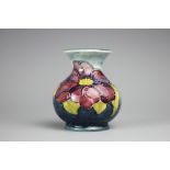 A Moorcroft Clematis pattern vase, decorated with two blooms against an ink blue ground,