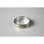 A white metal wedding band, with faceted design, stamped 'PLAT' 'S&W' '657', size L/M, weight 4.