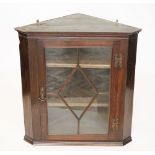 A George III style oak hanging corner cabinet, with astragal glazed door,