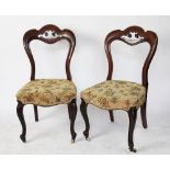 A set of four Victorian walnut dining chairs, with upholstered seats, on cabriole legs,