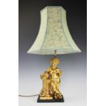 A French Empire style gilt bronze lamp, modelled as a cherub standing beside a column with books,