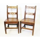 Three late George III country oak dining chairs, with pierced bar backs and solid seats,