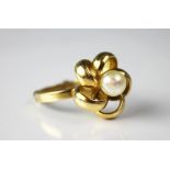A yellow metal flower ring with central 'pearl',