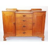 An Art Deco golden oak side cabinet, with four drawers flanked by two panelled doors,