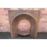 A Victorian cast iron fire insert, with arched centre,