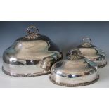 A set of four graduating silver plated meat covers, with gadrooned rims and scroll handles,
