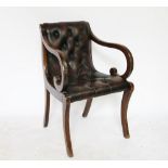 A Regency style stained beech library chair, with button leather upholstery, on sabre legs,