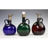 A near pair of 19th century white metal mounted glass decanters,