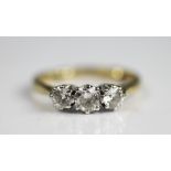 A three stone diamond ring, the three graduated brilliant cut diamonds each claw set in white metal,