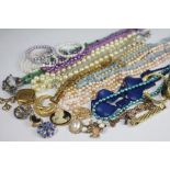 A quantity of assorted costume jewellery, to include; beads, bangles, clip earrinngs brooches,