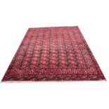 A large red ground Tekke Turkman style Bokhara pattern wool carpet,