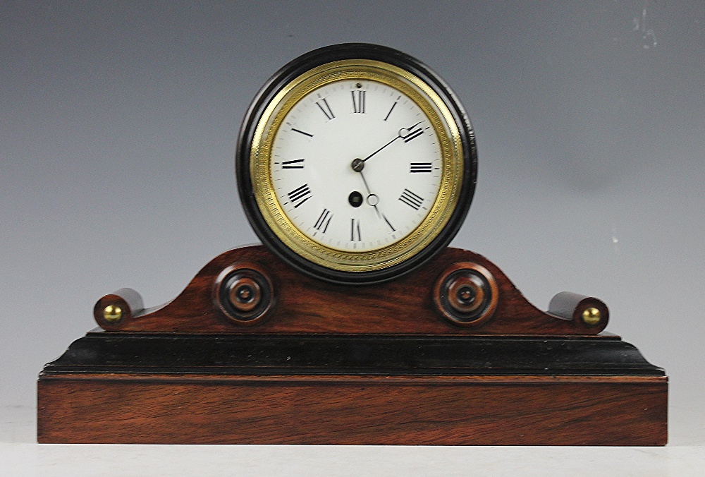 A late Victorian walnut mantel time piece, enamelled Roman numeral dial and eight day movement,